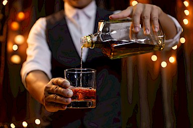 Barkeeper schenkt Rum ein bei Rum und Menü im auswärts
